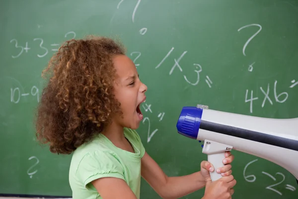 Vue latérale d'une écolière criant à travers un mégaphone — Photo