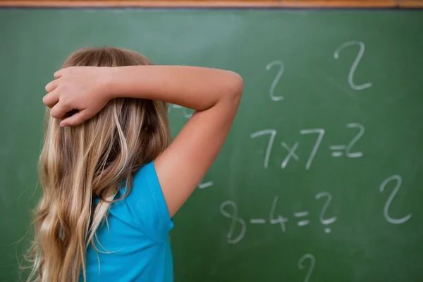 Piccola studentessa pensando mentre gratta la parte posteriore della testa — Foto Stock