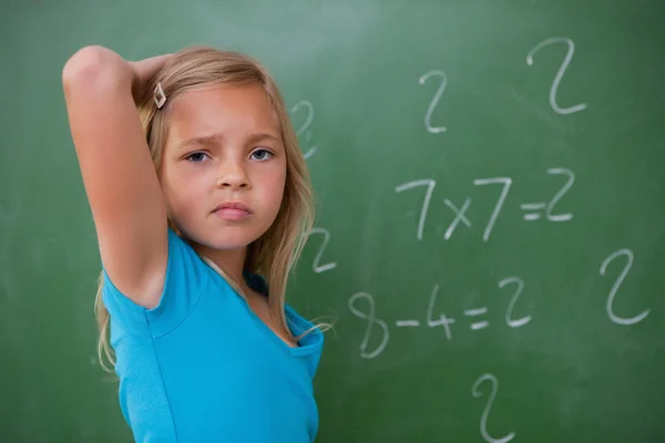 Schoolgirl thinking while scratching the back of her head — Stock Photo, Image
