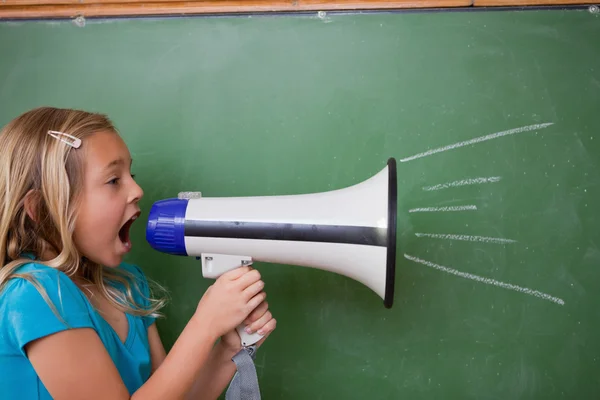 Young schoolgirl screaming through a megaphone — Stock Photo, Image