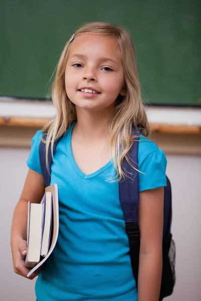 Portrait of a blonde schoolgirl holding her books — Stock Photo, Image