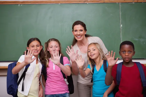Insegnante e le sue alunne che salutano la macchina fotografica — Foto Stock