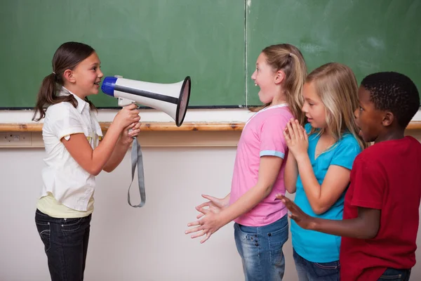 Écolière criant à travers un mégaphone à ses camarades de classe — Photo