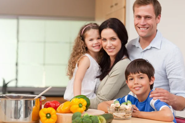 Sonriente familia de pie en la cocina —  Fotos de Stock