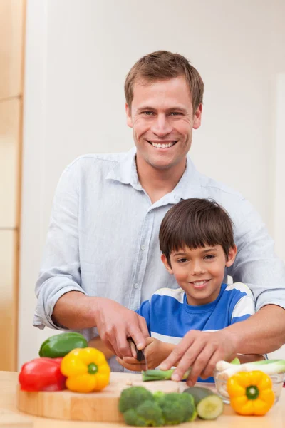Vader en zoon snijden groenten — Stockfoto