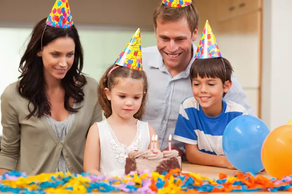Dziewczyna się zdmuchnąć świeczki na jej tort urodzinowy — Zdjęcie stockowe