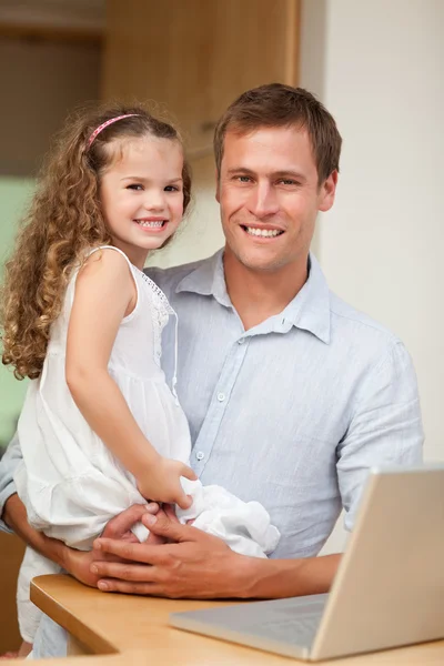 Отец показывает ноутбук своей дочери — стоковое фото