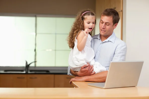 Girl is interested in her fathers laptop — Stock Photo, Image