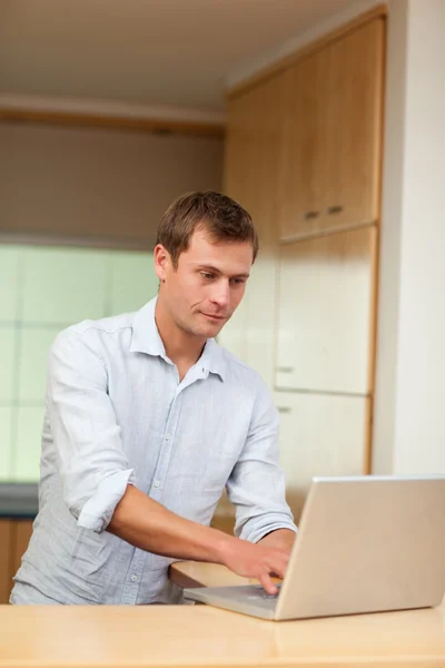 Masculino trabalhando em laptop na cozinha — Fotografia de Stock