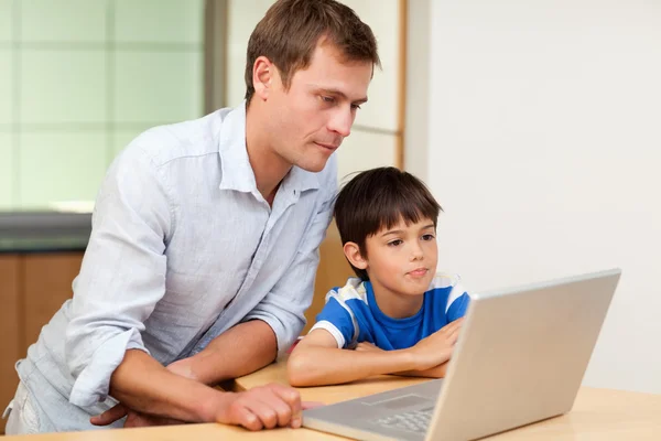Pai e filho olhando para laptop — Fotografia de Stock