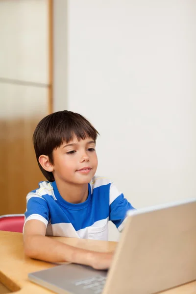 Мальчик играет в компьютерные игры на ноутбуке — стоковое фото