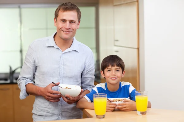 父亲和儿子有谷物和橙汁 — 图库照片