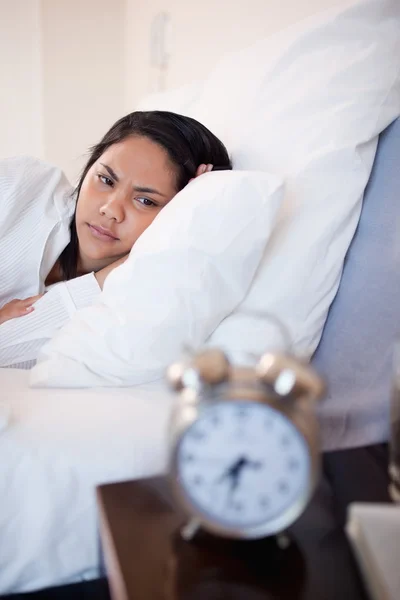 Side view of woman being annoyed by ringing alarm clock — Stock Photo, Image