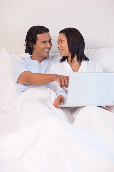 Paret sitter på sängen att surfa på internet — Stockfoto