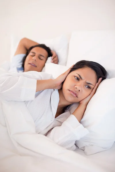 Mujer cubriéndose los oídos para bloquear a sus novios roncando —  Fotos de Stock
