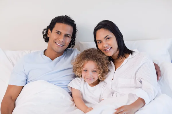Familjen sitter på sängen — Stockfoto