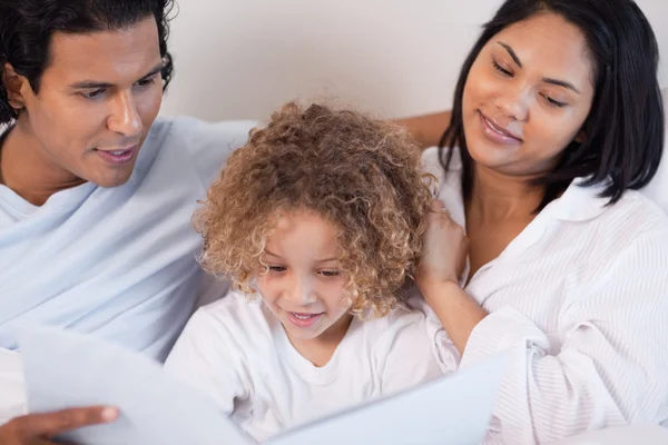 Happy family enjoys reading a book — Stock Photo, Image