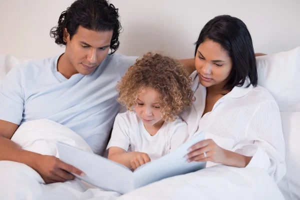 Ευτυχισμένη οικογένεια απολαμβάνει την ανάγνωση ενός βιβλίου μαζί — Φωτογραφία Αρχείου