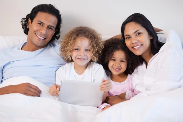 Rodina společně s notebookem v posteli — Stock fotografie