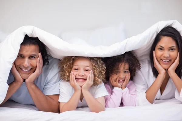 Família escondida sob o cobertor — Fotografia de Stock