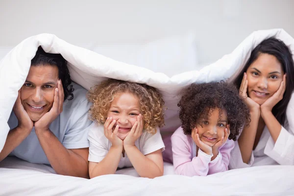 Family hiding under the bed cover — Stock Photo, Image