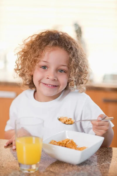Happy girl eating cereals for breakfast — Stock Photo, Image