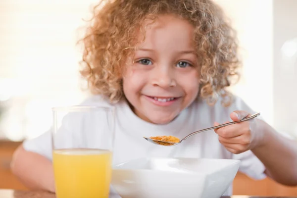 Leende flicka äter frukost i köket — Stockfoto