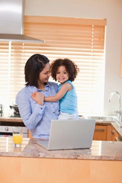 Mother and daughter with notebook in the kitchen — Stock Photo, Image