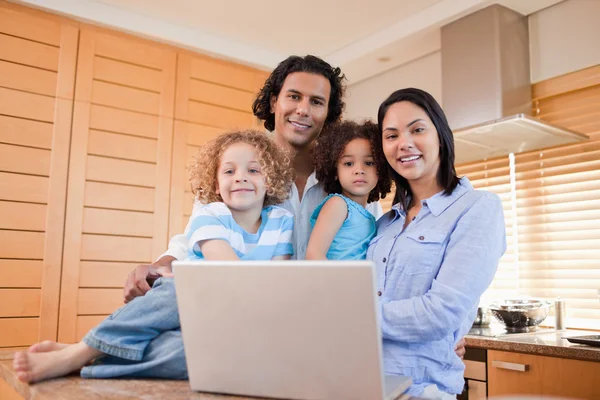 Ευτυχισμένη οικογένεια με laptop στέκεται στην κουζίνα μαζί — Φωτογραφία Αρχείου