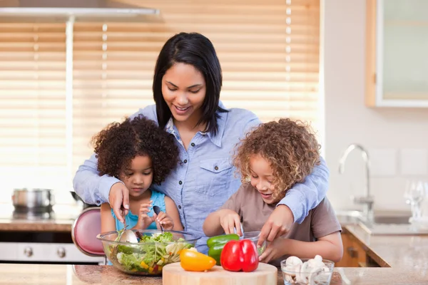 Madre e hijas preparando ensalada en la cocina juntas —  Fotos de Stock