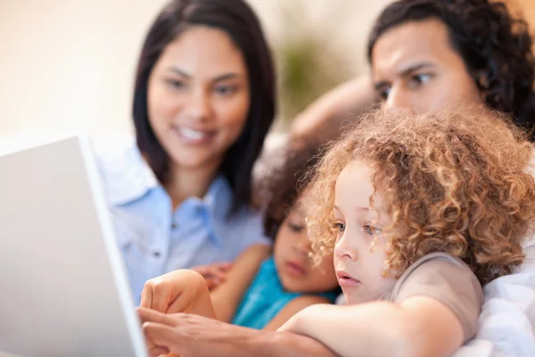 Glad familj använder laptop tillsammans — Stockfoto