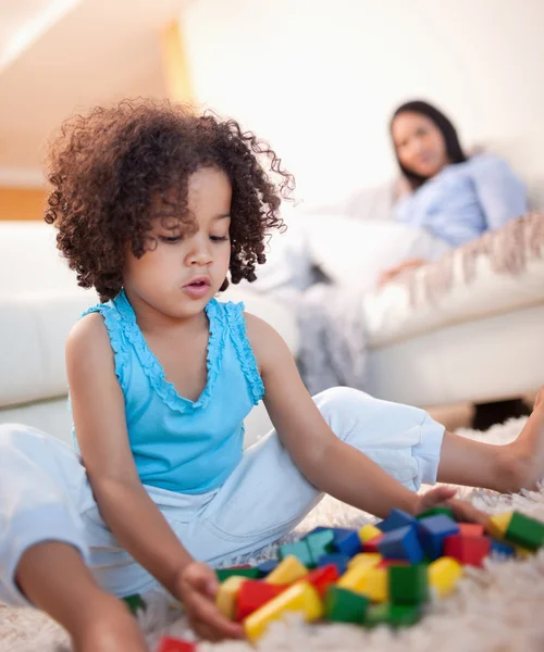 Menina na sala de estar brincando com blocos de brinquedo — Fotografia de Stock