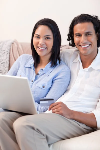 Couple with notebook on the couch — Stock Photo, Image