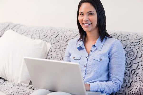 Lachende vrouw op de Bank met haar laptop — Stockfoto