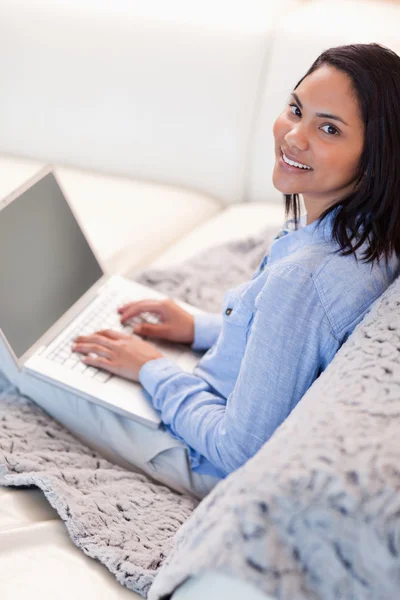 Žena s laptopem sedí na pohovce — Stock fotografie
