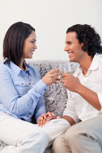 夫妇在沙发上喝香槟葡萄酒 — 图库照片