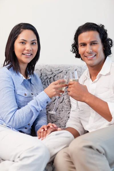 Paar trinkt Sekt auf der Couch — Stockfoto