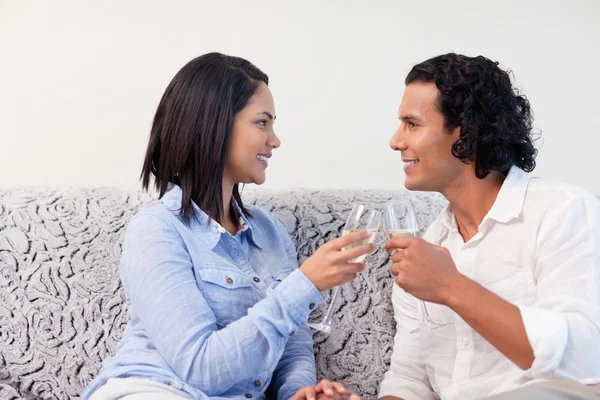 ソファの上でスパーク リング ワインを持っているカップル — ストック写真