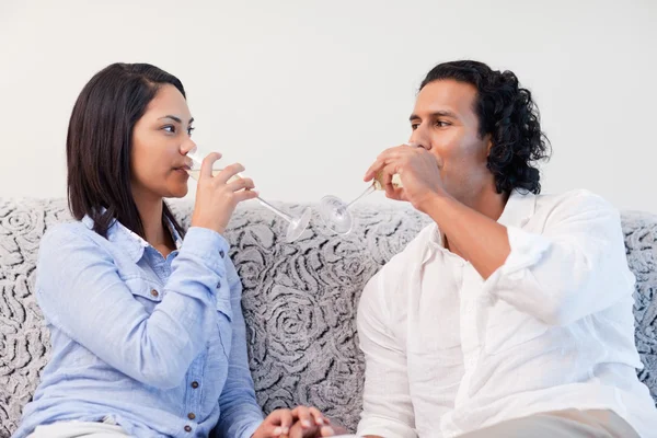 Par som dricker mousserande vin i vardagsrummet — Stockfoto
