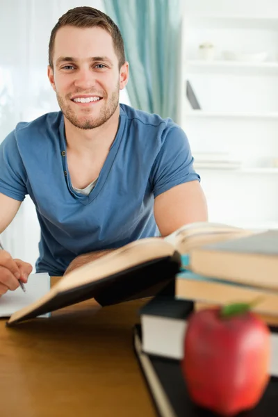 Smiling student with his assignment in front of him Stock Image