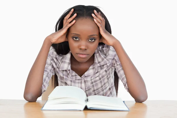Gelangweilte Studentin versucht ein Buch zu lesen Stockfoto