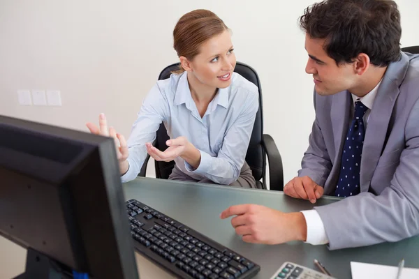 Trading partner sitting behind a desk while talking — Stock Photo, Image