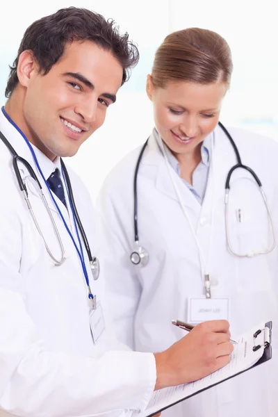 Assistant doctors with patient record — Stock Photo, Image