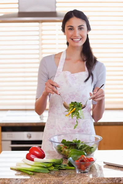 Porträt einer Frau, die einen Salat zubereitet lizenzfreie Stockbilder