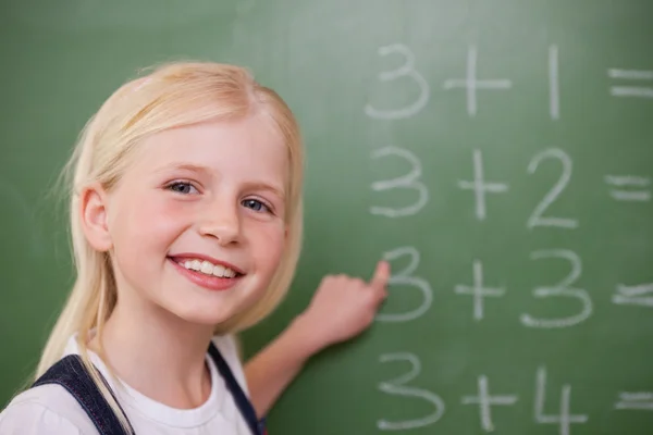 Blonde schoolgirl pointing at something Stock Picture