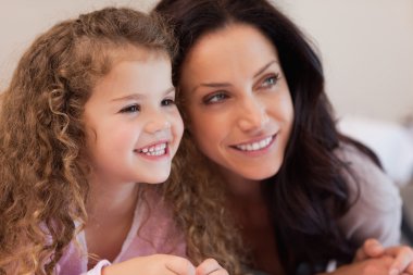 Mother and daughter lying close together clipart