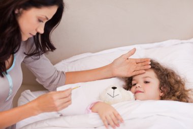 Mother measuring her daughters temperature clipart