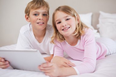 Children using a tablet computer clipart