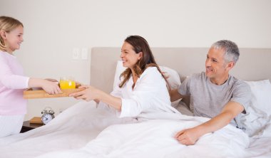 Girl serving breakfast to her parents clipart