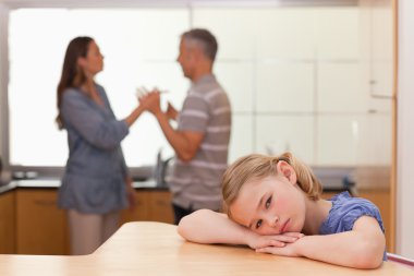 Sad girl hearing her parents arguing clipart